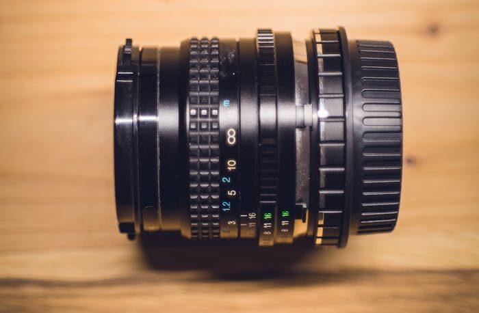 Black Camera Lens on Brown Wooden Table